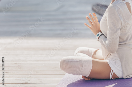 fitness  yoga and healthy lifestyle concept - group of people doing lotus seal gesture and meditating in seated pose at outdoor wooden terrace. Eastern spiritual practices  health of body and spirit