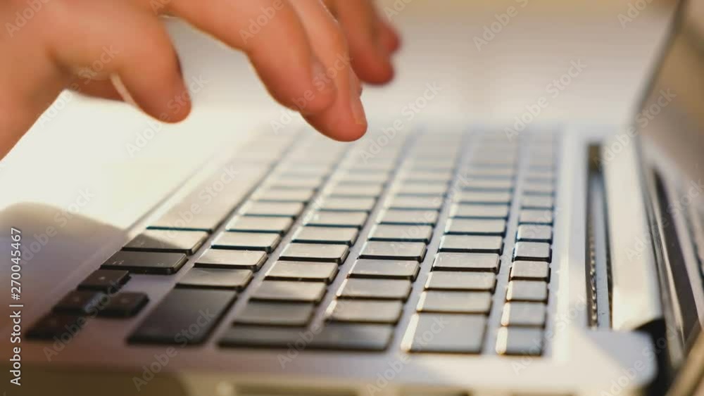 Close-up hands of an unidentified man quickly type on a laptop keyboard while writing a book. Writer work concept Close-up hands of an unidentified man quickly type on a laptop keyboard while writing a book. Writer work concept