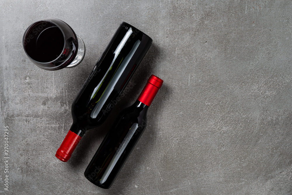 Naklejka premium Two bottles of wine glass on concrete background. Copy Space.