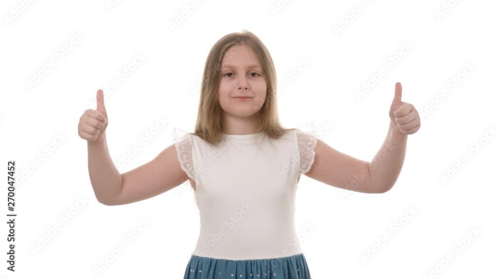 Video portrait of a pretty smiling girl holding thumbs up isolated on white background. Happy childhood concept. Studio shot of child emotions. Video portrait of a pretty smiling girl holding thumbs up isolated on white background. Happy childhood concept. Studio shot of child emotions.