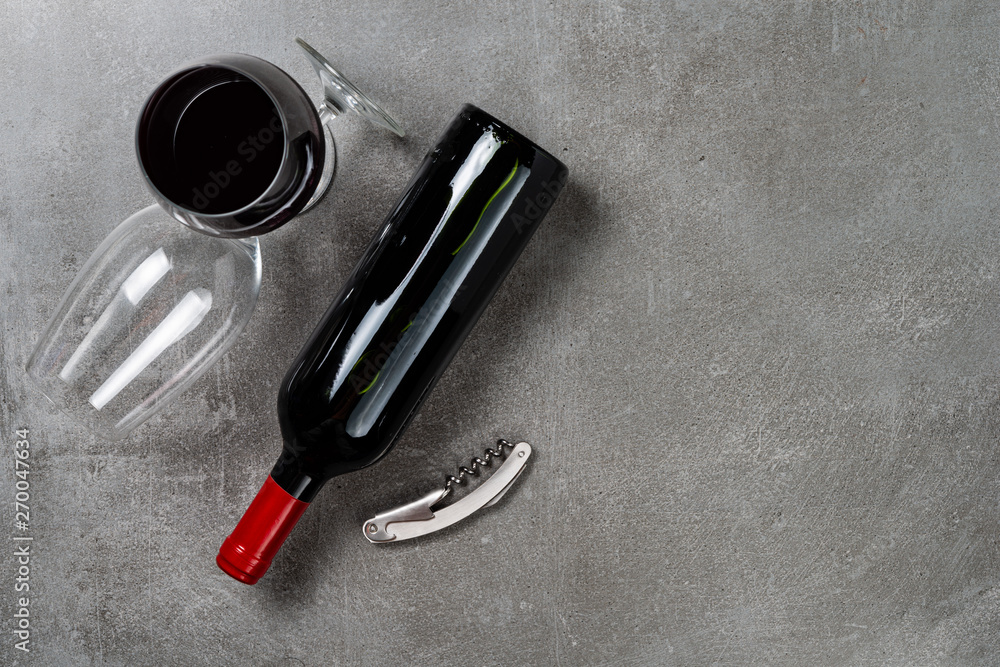 Naklejka premium Bottle of wine glasses and opener on concrete background. Copy Space.