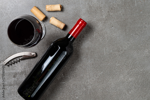 Wine bottle, cup, corks and opener on concrete background. Copy Space.