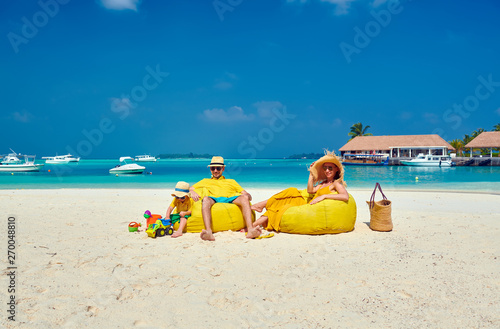 Fototapeta Naklejka Na Ścianę i Meble -  Family on beach, young couple in yellow with three year old boy. Summer vacation at Maldives.