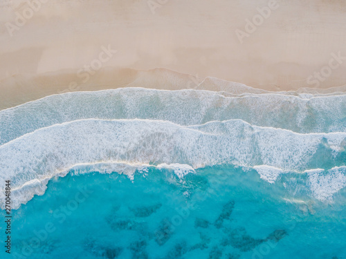 Aerial view of sand beach, ocean texture background looping, top down view of sea waves by drone.