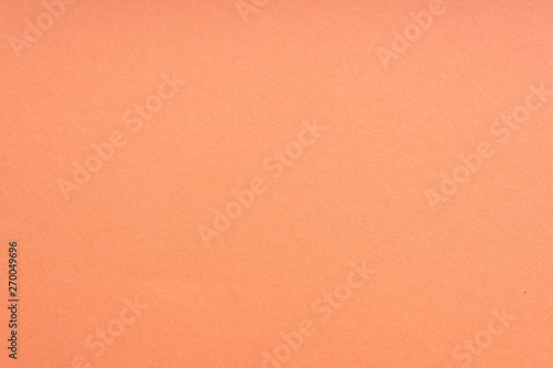 Paper background coral color. Rough paper texture. Closeup. Macro.