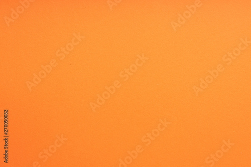 Paper background orange color. Rough paper texture. Closeup. Macro.