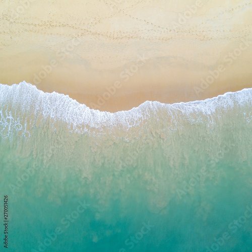 Obraz na płótnie Aerial view of turquoise ocean wave reaching the coastline