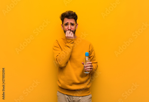 Young man biting nails, nervous and very anxious