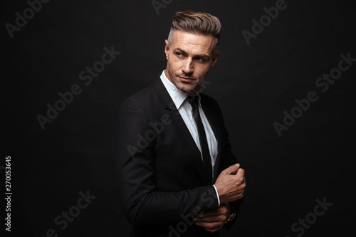 Photos Portrait of european unshaved businessman dressed in formal suit posing and look