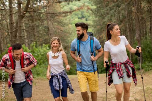 Happy young group hiking to...
