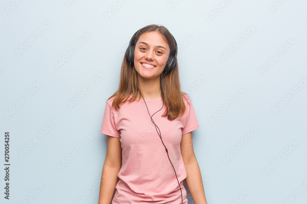 Young pretty caucasian woman cheerful with a big smile. She is listening to music with headphones. Young pretty caucasian woman cheerful with a big smile. She is listening to music with headphones.