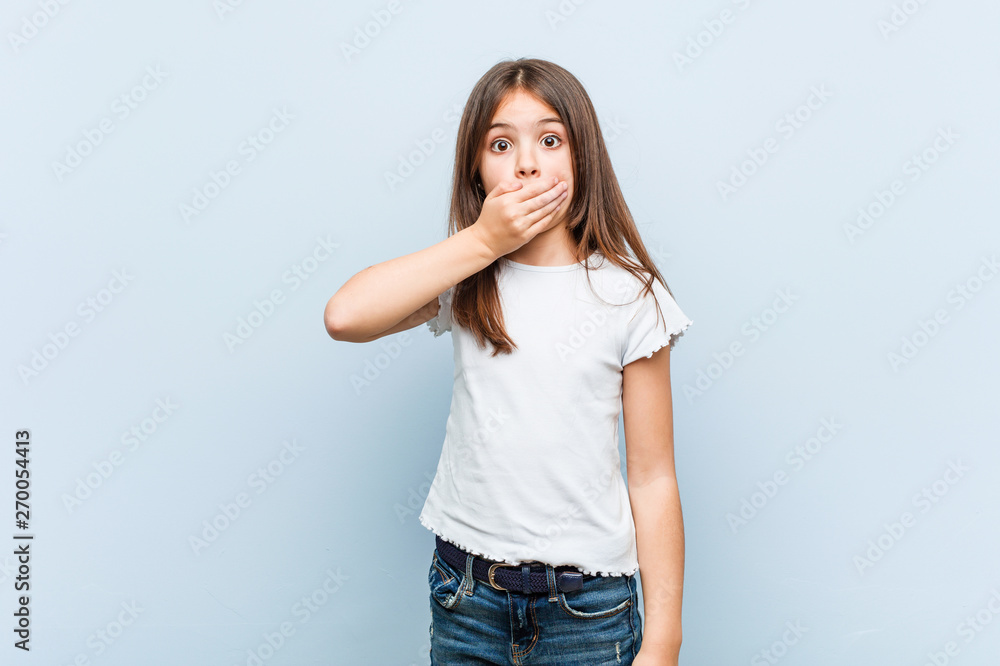 Cute girl thoughtful looking to a copy space covering mouth with hand. Cute girl thoughtful looking to a copy space covering mouth with hand.