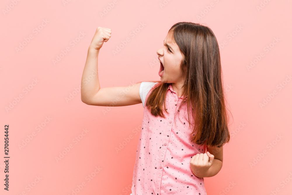 Cute little girl raising fist after a victory, winner concept. - obrazy, fototapety, plakaty 