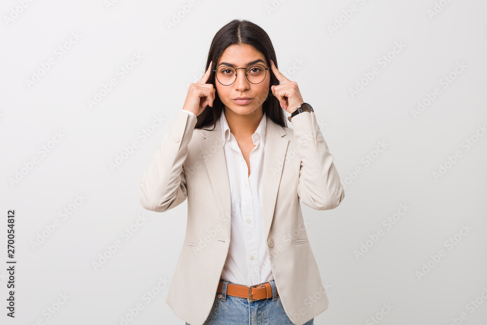 Young business arab woman isolated against a white background focused on a task, keeping forefingers pointing head. Young business arab woman isolated against a white background focused on a task, keeping forefingers pointing head.