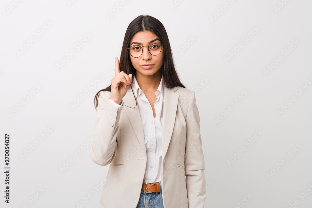 Young business arab woman isolated against a white background showing number one with finger. Young business arab woman isolated against a white background showing number one with finger.