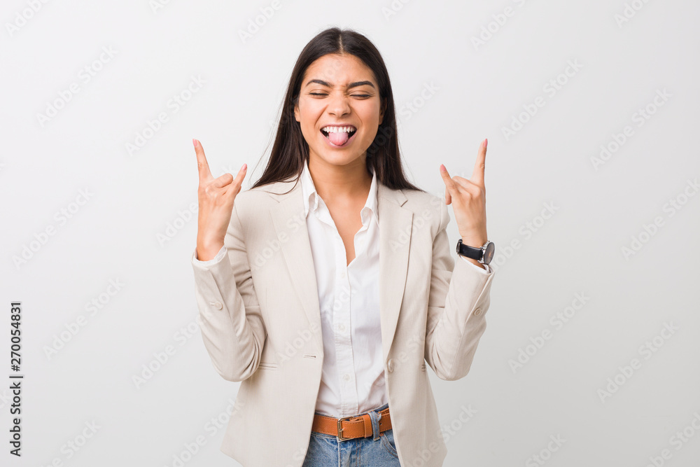 Young business arab woman isolated against a white background showing rock gesture with fingers Young business arab woman isolated against a white background showing rock gesture with fingers