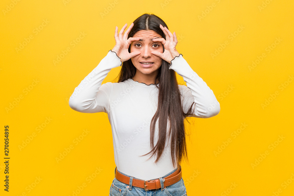 Young pretty arab woman against a yellow background keeping eyes opened to find a success opportunity. Young pretty arab woman against a yellow background keeping eyes opened to find a success opportunity.