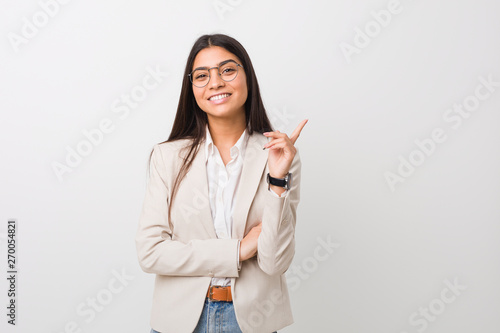 Young business arab woman isolated against a white background smiling cheerfully pointing with forefinger away.