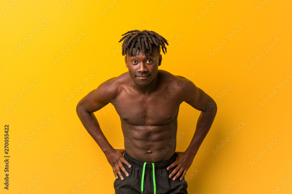 Fototapeta premium Young black man shirtless wearing swimsuit scolding someone very angry.
