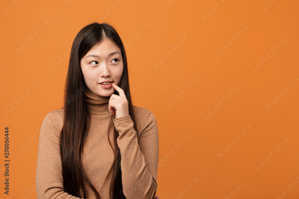 Young pretty chinese woman relaxed thinking about something looking at a copy space. Young pretty chinese woman relaxed thinking about something looking at a copy space.