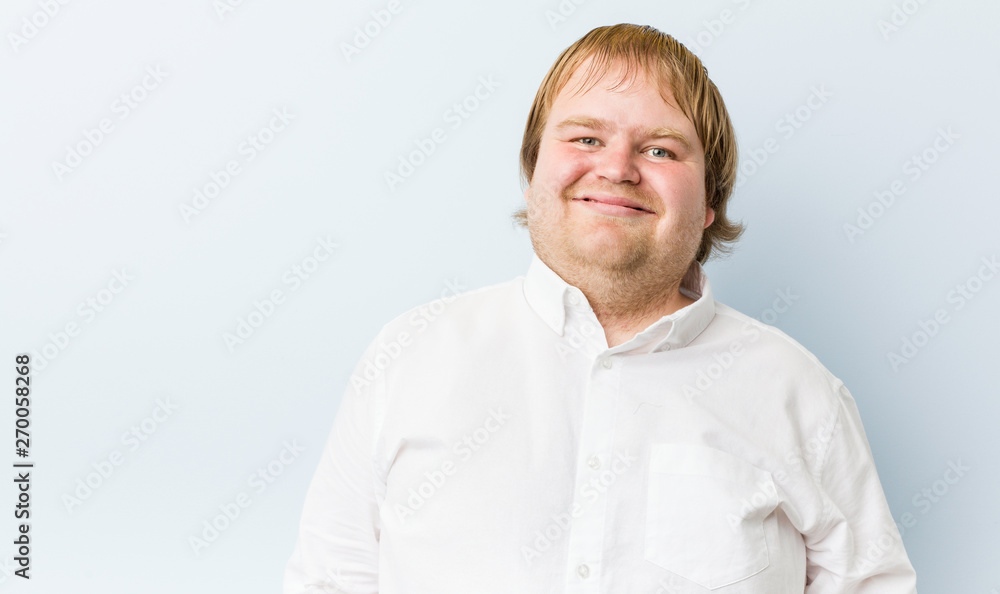 Obraz premium Young authentic redhead fat man laughs and closes eyes, feels relaxed and happy.