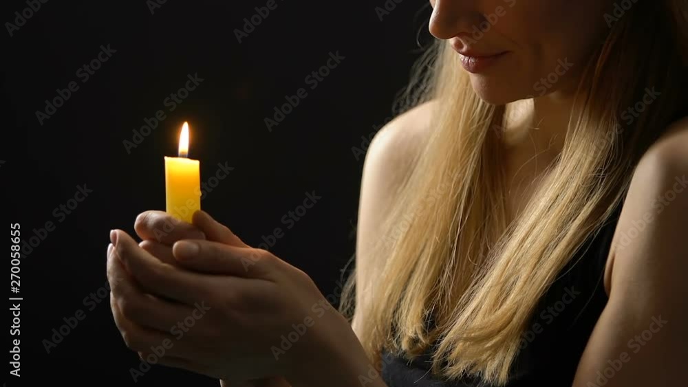 Peaceful smiling lady holding burning candle hoping for better, faith and belief Peaceful smiling lady holding burning candle hoping for better, faith and belief