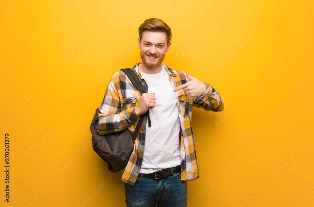Young redhead student man person pointing by hand to a shirt copy space, proud and confident Young redhead student man person pointing by hand to a shirt copy space, proud and confident