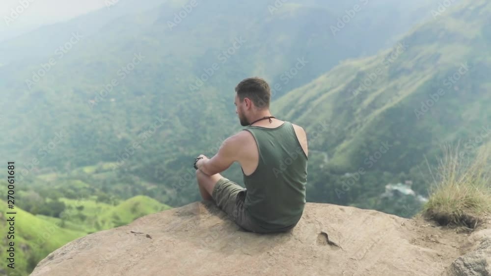 Man sitting on top of mountain Man sitting on top of mountain