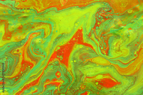 photography of abstract marbleized effect background. green and orange creative colors