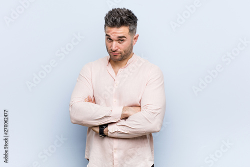 Young handsome cool man unhappy looking in camera with sarcastic expression.