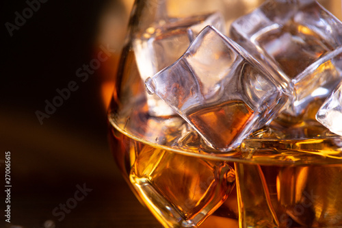 a glass of whiskey on wooden table