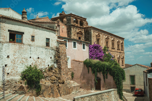 Old buildings and flowering trees over an alleyway at Caceres