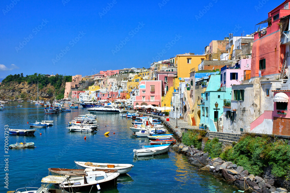 Colorful island town in Italy. Pastel buildings lining the boat filled harbor of Procida.