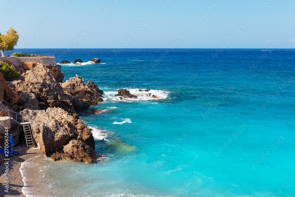 Beautiful blue lagoon with umbrellas at sandy beach, Chora Sfakion town, Crete island, Greece