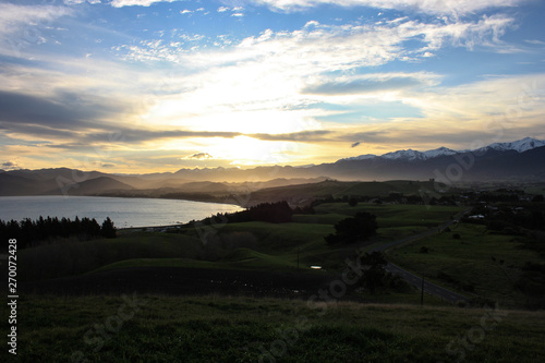 Colorful sunset over the meadows and the mountain range of the east coast of the North Island, New Zealand