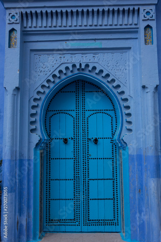 Traditional moroccan wooden door as an architectural detail in the streets of the Blue City, Chefchaouen, Morocco © rutkowskii