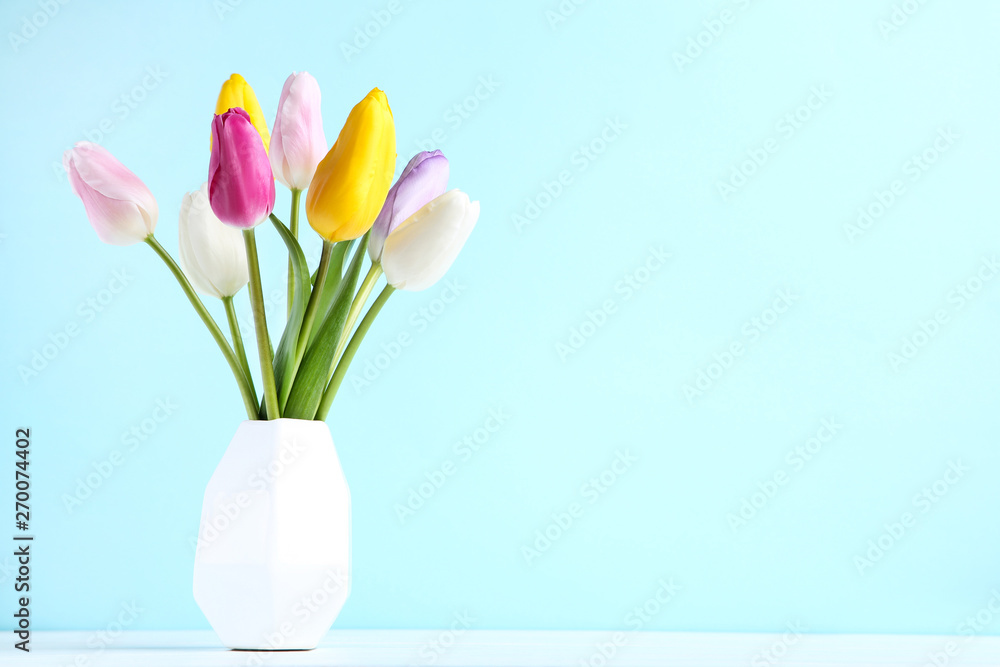 Bouquet of tulip flowers in vase on blue background Bouquet of tulip flowers in vase on blue background