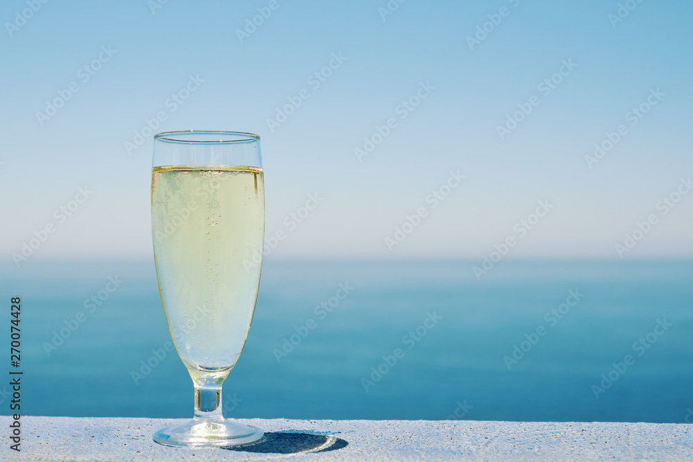 Glass of white dry wine over seaside background, summertime. Glass of white dry wine over seaside background, summertime.