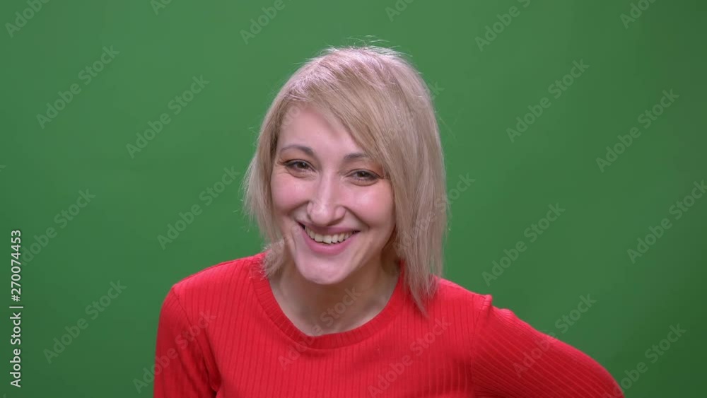 Middle-aged blonde short-haired model laughing joyfully isolated on green chromakey background. Middle-aged blonde short-haired model laughing joyfully isolated on green chromakey background.