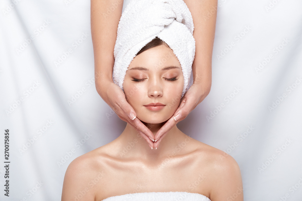 pretty woman in bath towel on her head receiving facial massage, beauty theraphy after bath, spa treatment for females