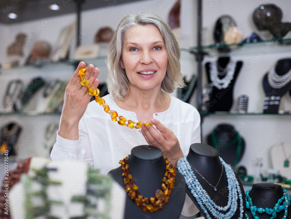 Φωτογραφία Woman trying on a aventurine necklace and earrings at a jewelry store