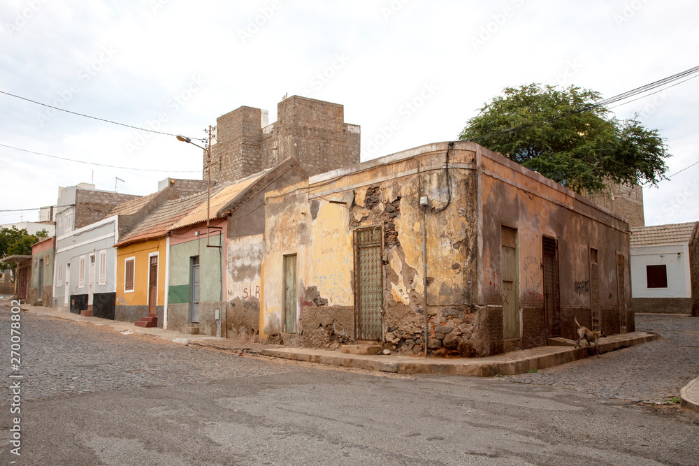 Derelict house and stray dog on the corner of a street in Mindelo on island Sao Vicente in Cape Verde.