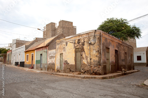 Derelict house and stray dog on the corner of a street in Mindelo on island Sao Vicente in Cape Verde.