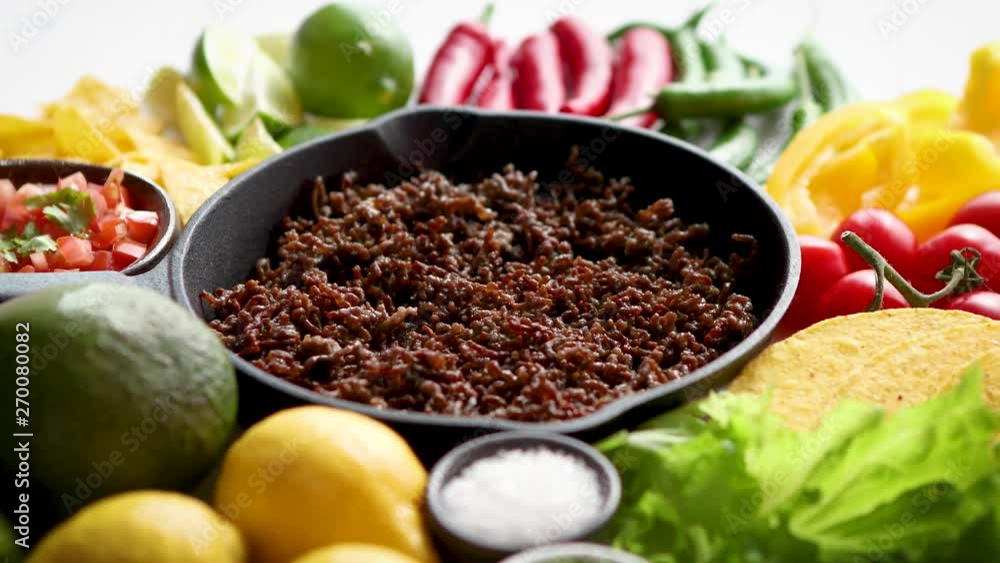 Ingredients for Chili con carne in frying iron pan on white wooden table Ingredients for Chili con carne in frying iron pan on white wooden table