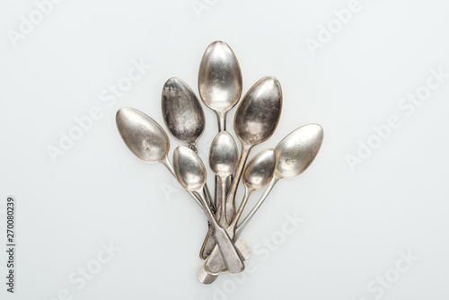 top view of shiny vintage silver empty spoons on white background © LIGHTFIELD STUDIOS