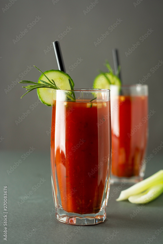 Glasses of tasty tomato juice isolated on gray table Glasses of tasty tomato juice isolated on gray table