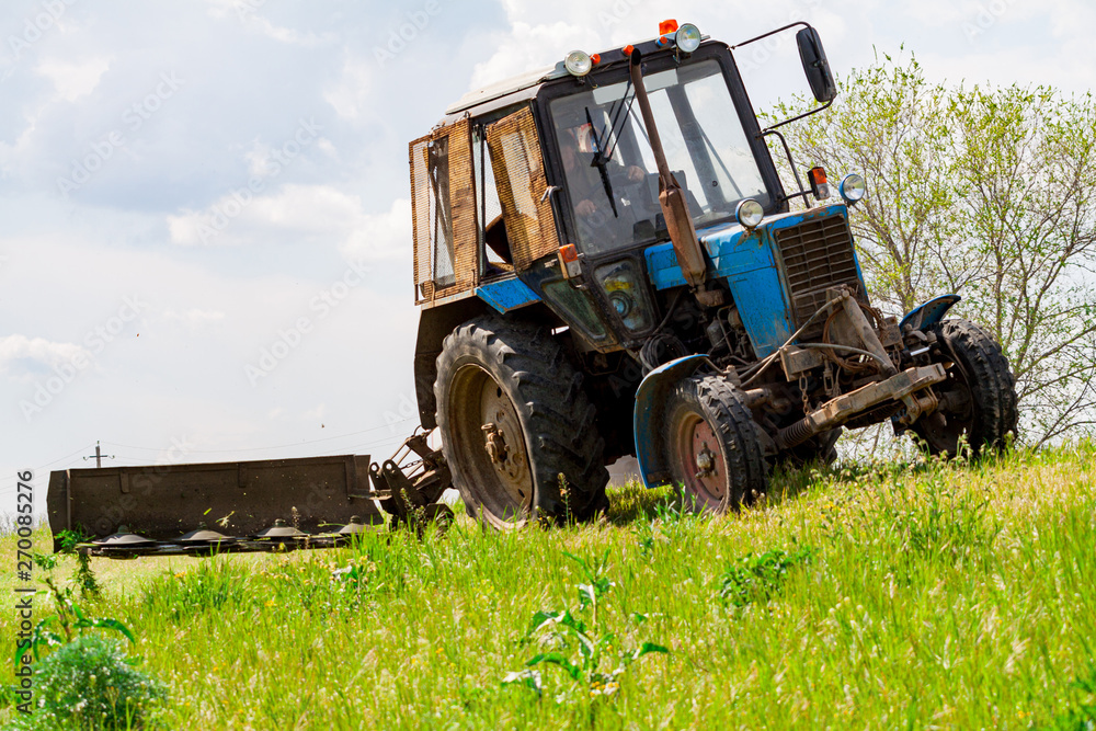 Obraz premium Tractor with a mechanical mower mowing grass