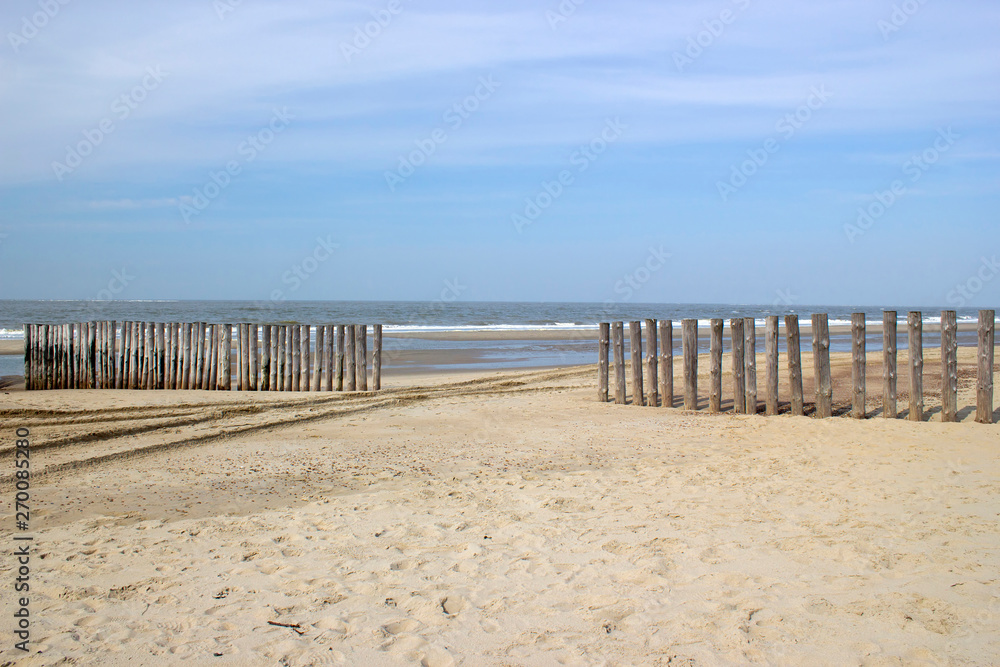Wave breaker made of wooden stakes on the beach, Renesse, Netherlands Wave breaker made of wooden stakes on the beach, Renesse, Netherlands