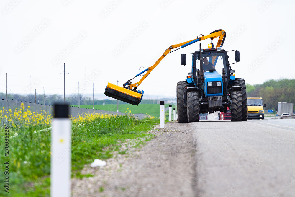 Tractor with a mechanical mower mowing grass