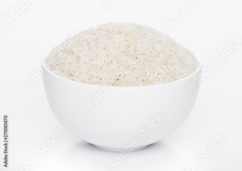 White bowl of raw organic basmati rice on white background. Healthy food.